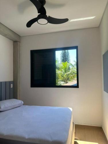 a bedroom with a flat screen tv on the wall at Pousada Bettys in Ubatuba