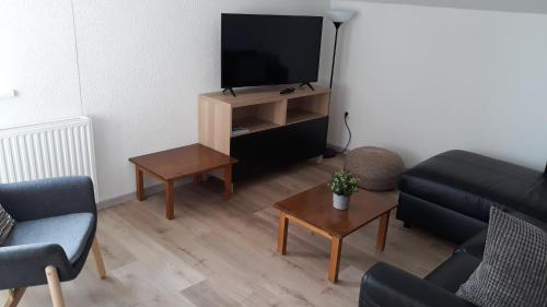 エールヴァルトにあるHaus Linnのソファとテレビのあるリビングルーム