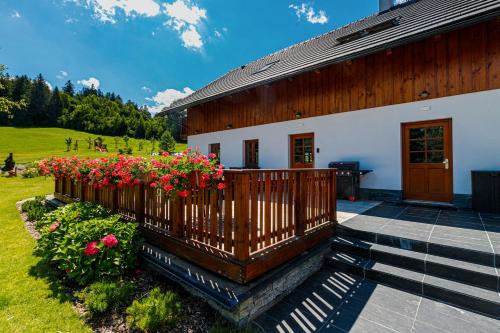 a house with a porch with flowers on it at Penzion Stříbrník in Krásná
