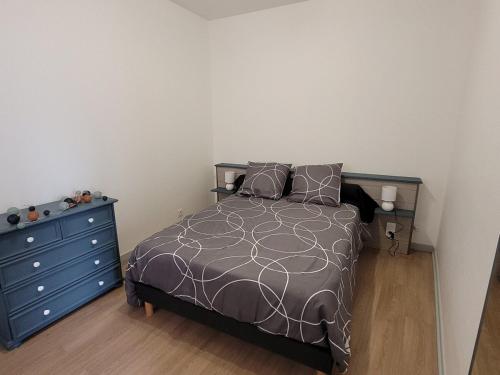 a bedroom with a bed and a blue dresser at Appartement F1 in Bas-en-Basset