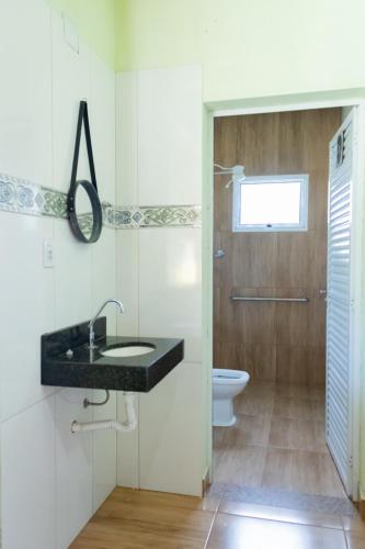 a bathroom with a sink and a toilet at Casa bem equipada com piscina,churrasqueira e WiFi in Confins