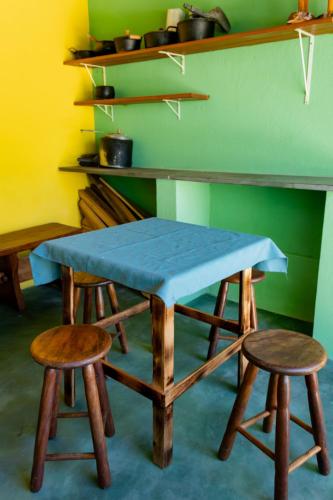 a table and two stools in a room at Casa bem equipada com piscina,churrasqueira e WiFi in Confins