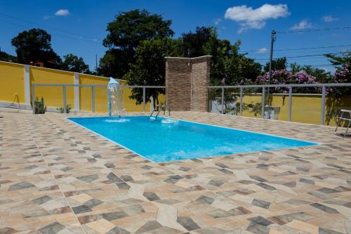 a swimming pool with a fountain in a yard at Casa bem equipada com piscina,churrasqueira e WiFi in Confins
