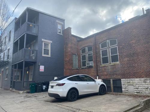 a white car parked in front of a brick building at Condo in OTR, Pendleton Art District in Cincinnati