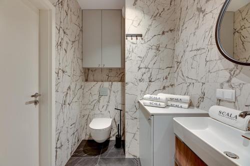 a white bathroom with a sink and a toilet at Scala City Center Premium Apartments with Parking by Lion Apartments in Gdańsk