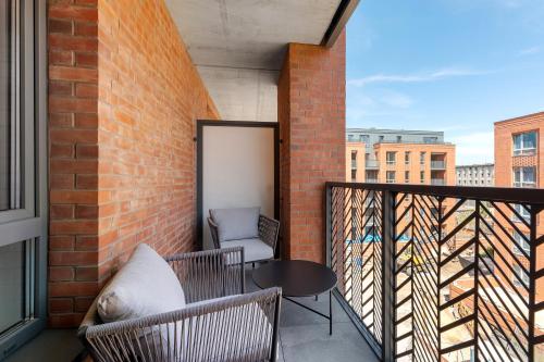 a balcony with a table and chairs on a brick wall at Scala City Center Premium Apartments with Parking by Lion Apartments in Gdańsk
