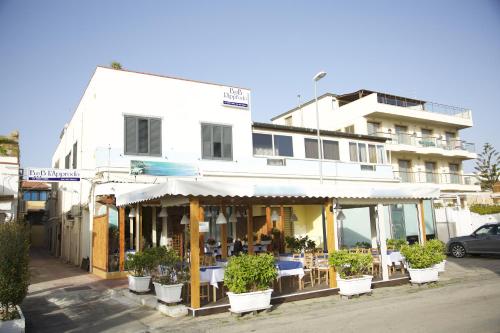 a white building with potted plants in front of it at L'Approdo in San Leone