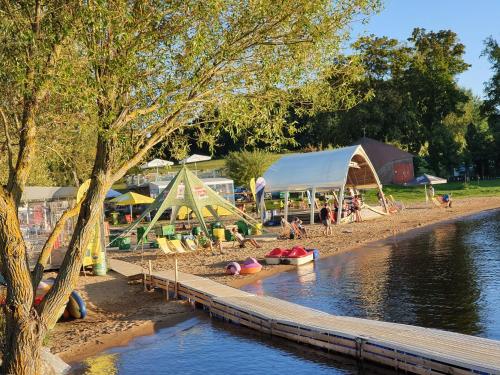 a park with a playground and tents next to the water at Relax Vila Lipno- apartmán v podkroví u pláže Windy Point in Černá v Pošumaví