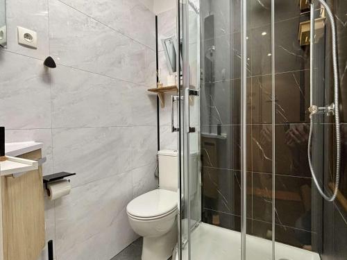 une salle de bain avec toilettes et douche en verre dans l'établissement Argelès-sur-Mer : T2 Climatisé à 50m de la Plage, Balcon, TV, Lave-linge - FR-1-225-810, à Argelès-sur-Mer
