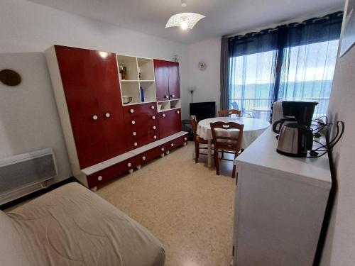 une chambre avec une cuisine et une chambre avec une table dans l'établissement F2 à Balaruc-les-Bains avec vue sur l'étang, proche Thermal, 1 chambre, non-fumeur - FR-1-571-64, à Balaruc-les-Bains