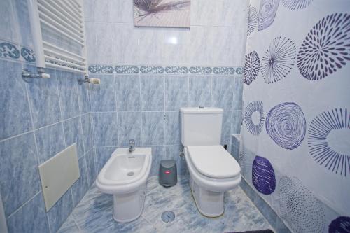 a bathroom with a toilet and a sink at Villa As Cumadres in Azeitao