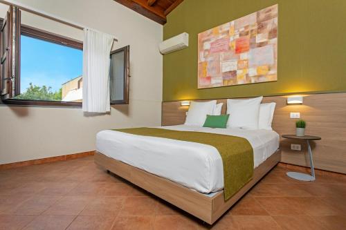 a bedroom with a large bed and a window at Feudogrande Bio Relais Hotel in Fiumefreddo di Sicilia
