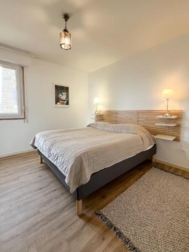une chambre avec un grand lit et une fenêtre dans l'établissement Bel Appartement Face à La Plage, à Erquy