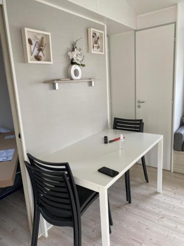 - une table et des chaises blanches dans la chambre dans l'établissement Mobile home 4-6 places Camping les sables du midi Valras, à Sérignan