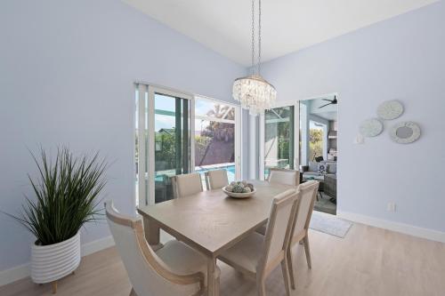 a dining room with a table and chairs at 2023 custom built home with heated pool and hot tub in Marco Island