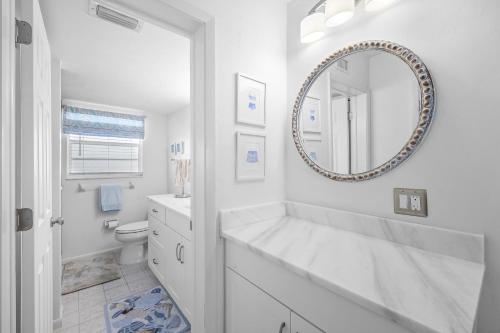 a white bathroom with a sink and a mirror at Coastal condo just a short walk away from the beach in Marco Island