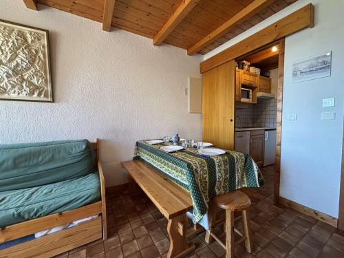 Cette chambre dispose d'une table, d'un banc et d'une cuisine. dans l'établissement À deux pas des pistes : Appartement 2 pièces cabine à Crest-Voland – 4-6 pers. - FR-1-595-65, à Crest-Voland