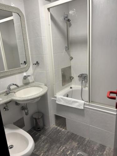 a white bathroom with a sink and a shower at Hotel Park in Našice