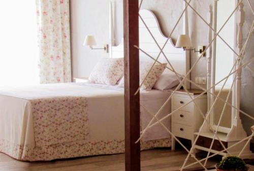 a bedroom with a canopy bed and a dresser at Suites BELLAHELLIN in Hellín