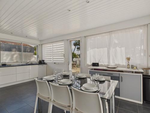 une cuisine avec une table et des chaises dans une pièce dans l'établissement Maison pour 8 - Terrasse - Barbecue - 500 m plage, à Bretignolles-sur-Mer