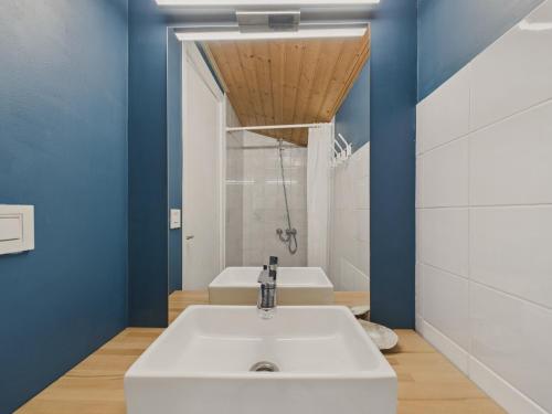 ein Badezimmer mit einem weißen Waschbecken und blauen Wänden in der Unterkunft Maison pour 8 - Terrasse - Barbecue - 500 m plage in Brétignolles-sur-Mer