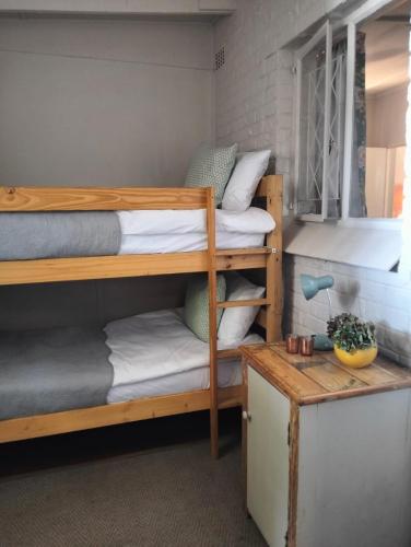 a room with two bunk beds and a table at Primula Cottage at Hillhouse in Hilton