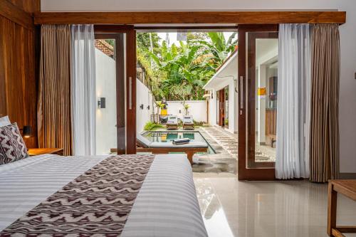 une chambre avec un lit et vue sur une cour dans l'établissement Umah Asri, à Ubud