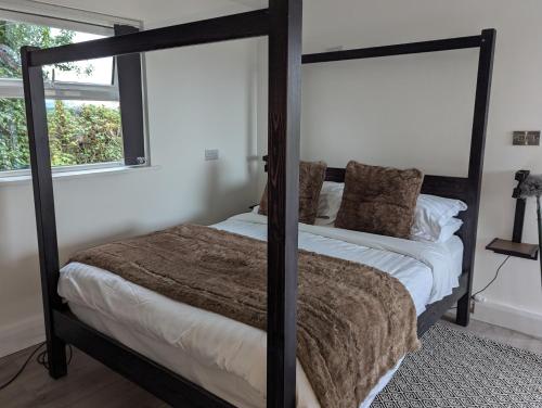 a bedroom with a four poster bed and a window at Willowbank House in Enniskillen