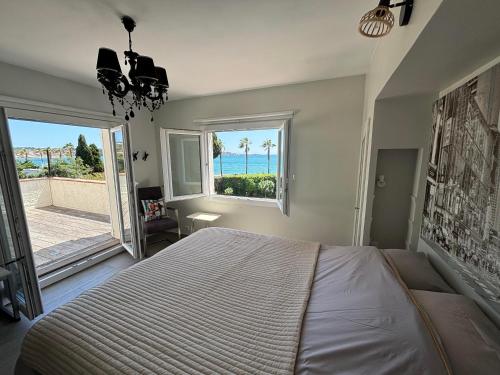 une chambre avec un lit et une vue sur l'océan dans l'établissement Magnifique Villa en bord de mer, à Sanary-sur-Mer