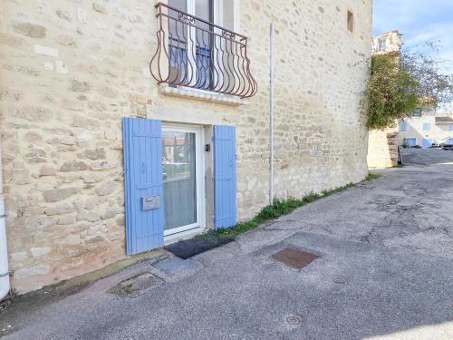 una puerta azul en el lateral de un edificio en Le Studio, Saint-Restitut, en Saint-Restitut