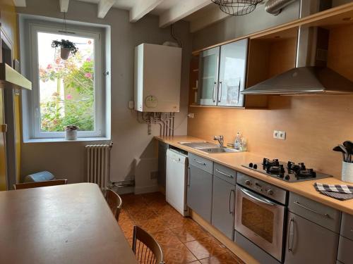 a kitchen with a sink and a stove top oven at Charmante Maison in Cherbourg en Cotentin