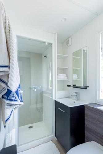 une salle de bain blanche avec une douche et un lavabo dans l'établissement Camping maeva Respire de la Baie, à Assérac