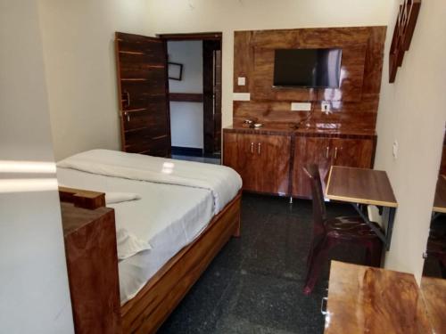 a bedroom with a bed and a desk and a television at HOTEL COASTAL GRAND Inn in Visakhapatnam