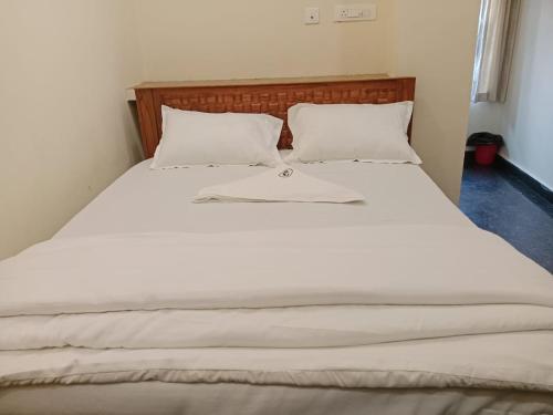 a bed with white sheets and pillows in a room at HOTEL COASTAL GRAND Inn in Visakhapatnam