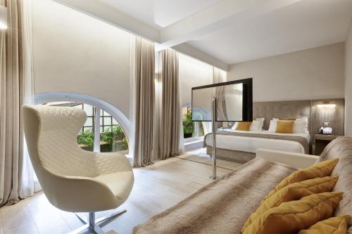a bedroom with a bed and a chair and a mirror at Terrace Pantheon Relais in Rome