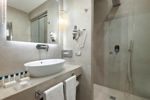 a white bathroom with a sink and a shower at Terrace Pantheon Relais in Rome