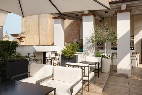 an outdoor patio with white chairs and tables at Terrace Pantheon Relais in Rome