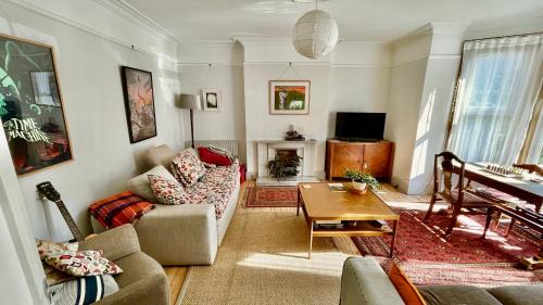 a living room with a couch and a table at Augusta garden apartment in Sheringham