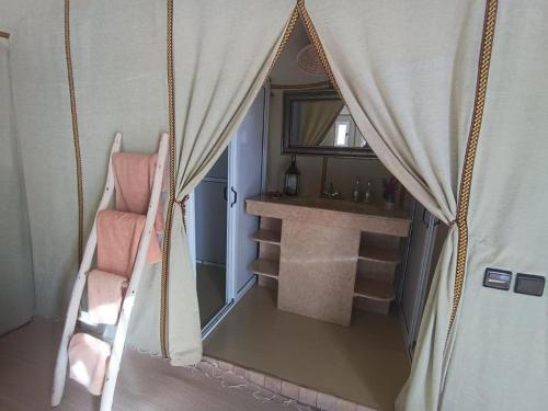 a room with a tent with a chair and a window at Sultana Merzouga camp in Merzouga
