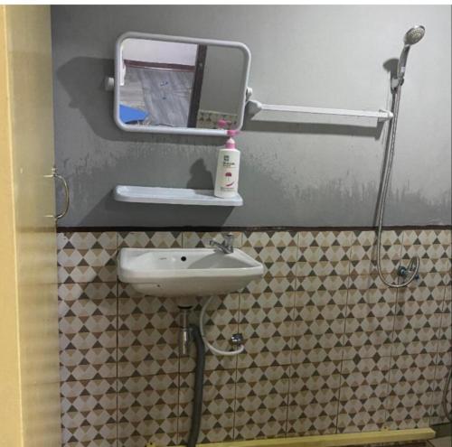 a bathroom with a sink and a mirror at New Saran Hostel krabi in Krabi town