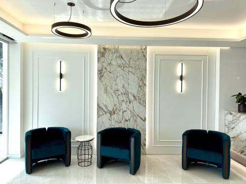 a living room with two blue chairs and a chandelier at Le Naiadi Park Hotel Sul Lago in Bolsena