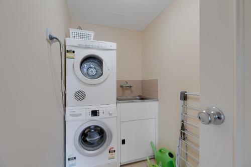 a laundry room with a washing machine and a washer at Stylish 1BR Beachside Escape - Heart of Gold Coast in Gold Coast