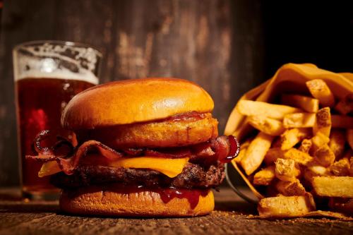 a cheeseburger and french fries and a glass of beer at Holiday Inn & Suites Richmond West End by IHG in Richmond