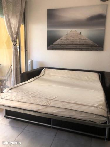 Ce lit se trouve dans un dortoir avec une photo d'une jetée. dans l'établissement un cocon proche de la mer, à Narbonne