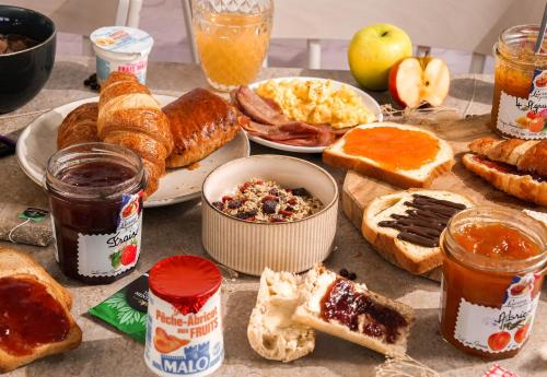 una mesa cubierta con muchos tipos diferentes de alimentos para el desayuno en B&B HOTEL Saint-Nazaire Trignac, en Trignac