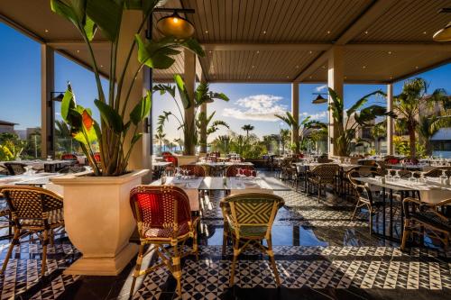 a restaurant with tables and chairs with a view of the ocean at Hotel Riu Palace Tikida Agadir - All Inclusive in Agadir