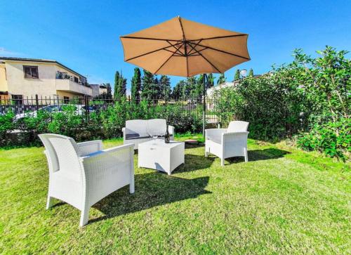 a patio with a table and chairs and an umbrella at Villa Charme & Relax in Campofelice di Roccella
