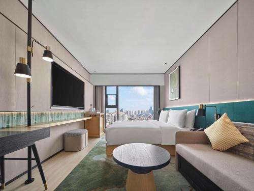 a hotel room with a bed and a couch at Hilton Garden Inn Chengdu Tianfu Panda Tower in Chengdu