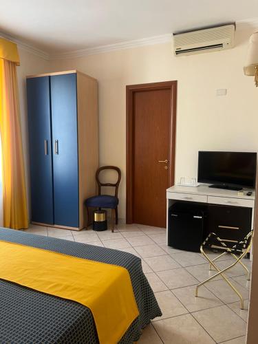 ein Schlafzimmer mit einem Bett, einem Schreibtisch und einem Fernseher in der Unterkunft Città Eterna Guest House in Rom