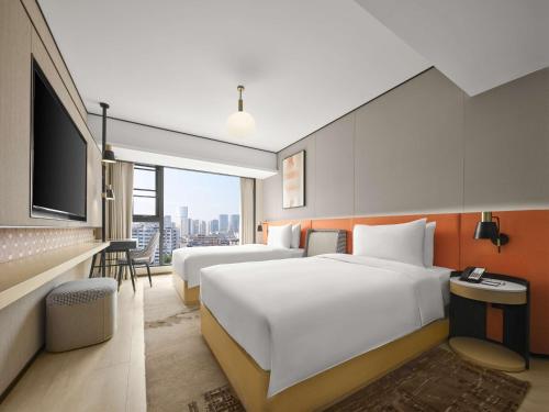 a hotel room with two beds and a flat screen tv at Hilton Garden Inn Chengdu Tianfu Panda Tower in Chengdu